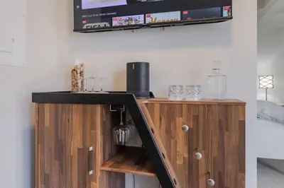 a kitchen with a wooden cabinet with glasses on it at Modern Down Town Condo Near CN Tower with Fast WiFi in Toronto