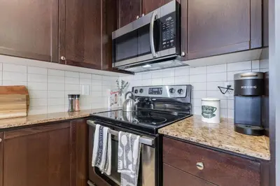 a kitchen with a stove and a microwave at Modern Down Town Condo Near CN Tower with Fast WiFi in Toronto