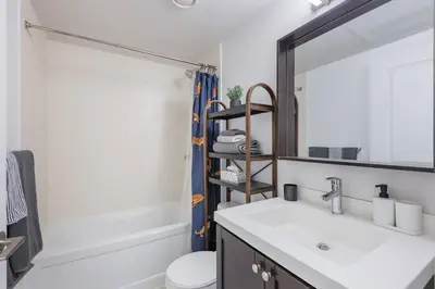 a bathroom with a sink and a mirror at Modern Down Town Condo Near CN Tower with Fast WiFi in Toronto