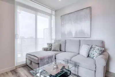 a living room with a couch and a table at Down Town CN Tower View 2BR Condo with Balcony and WiFi in Toronto