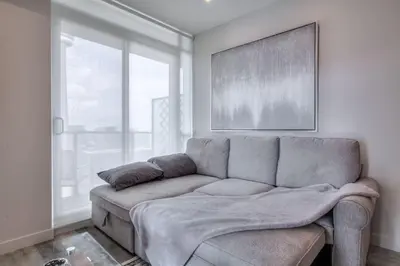 a living room with a couch in front of a window at Down Town CN Tower View 2BR Condo with Balcony and WiFi in Toronto