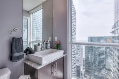 a bathroom with a sink and a large window at Down Town CN Tower View 2BR Condo with Balcony and WiFi in Toronto