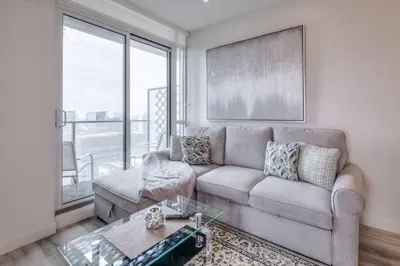 a living room with a couch and a glass table at Down Town CN Tower View 2BR Condo with Balcony and WiFi in Toronto
