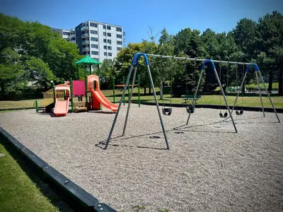 a playground with a swing set in a park at Lower Penthouse Suite with Pools & Sunset Views in Toronto