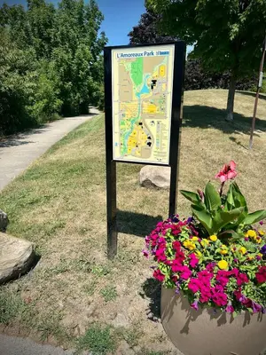 a sign in a park with flowers in a pot at Lower Penthouse Suite with Pools & Sunset Views in Toronto