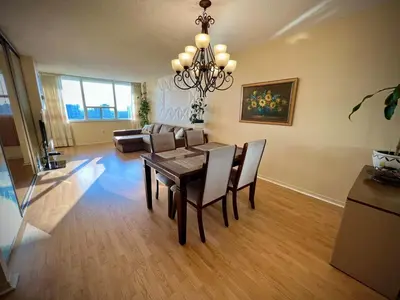 a living room with a table and a couch at Lower Penthouse Suite with Pools & Sunset Views in Toronto