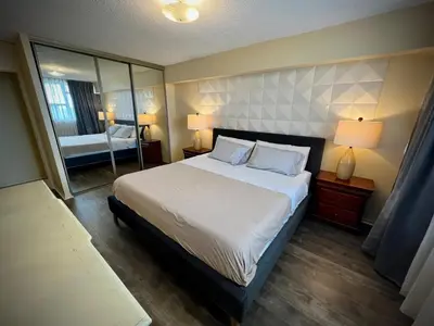 a bedroom with a large bed and a mirror at Lower Penthouse Suite with Pools & Sunset Views in Toronto