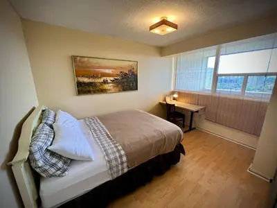 a bedroom with a bed and a desk and a window at Lower Penthouse Suite with Pools & Sunset Views in Toronto