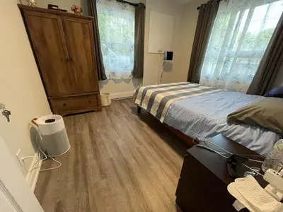 a bedroom with a bed and a wooden floor at Comfortable waterfront vacation Keswick in Georgina