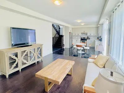 a living room with a couch and a tv at Beautiful Brand New House in Keswick 8 guests in Georgina
