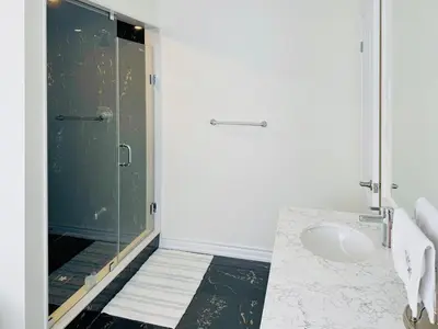 a bathroom with a shower with a glass door at Beautiful Brand New House in Keswick 8 guests in Georgina