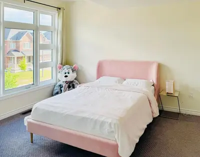 a pink bed with a stuffed animal sitting next to a window at Beautiful Brand New House in Keswick 8 guests in Georgina