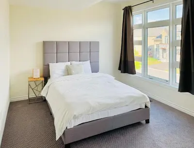 a bedroom with a large bed and a window at Beautiful Brand New House in Keswick 8 guests in Georgina