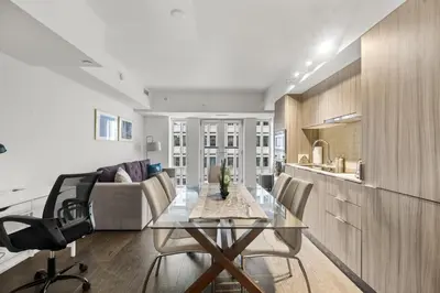 a kitchen and living room with a glass table and chairs at Modern 1Bd & Den in Downtown Toronto in Toronto