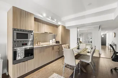 a kitchen and dining room with a table and chairs at Modern 1Bd & Den in Downtown Toronto in Toronto