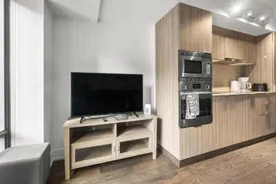 a living room with a tv and a table with a tvictericterictericter at Modern 1Bd & Den in Downtown Toronto in Toronto