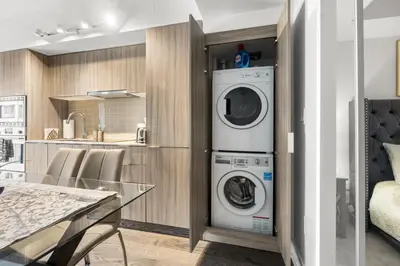 a kitchen with a washer and dryer in a room at Modern 1Bd & Den in Downtown Toronto in Toronto