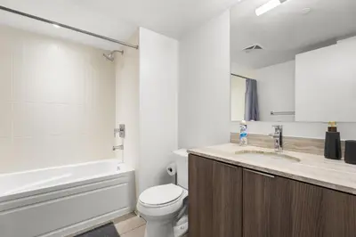 a bathroom with a toilet and a sink and a tub at Modern 1Bd & Den in Downtown Toronto in Toronto