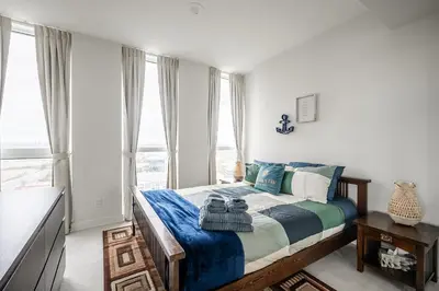 a bedroom with a bed with blue and white sheets at Panoramic view Condo 2 BR 2 BA Free parking in Toronto