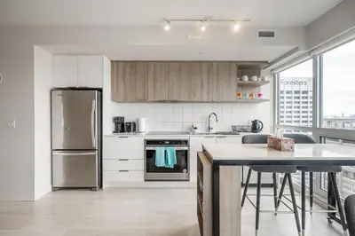 a kitchen with a stainless steel refrigerator and a table at Panoramic view Condo 2 BR 2 BA Free parking in Toronto
