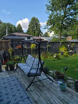 a swing on a deck in a yard at Equipped Basement Great Location in London