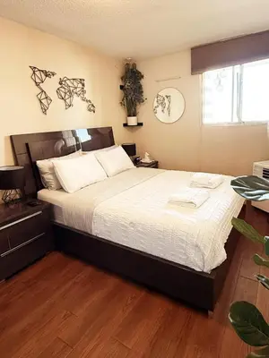 a bedroom with a large bed with white sheets at DT Apt great view whit garden in Toronto