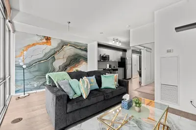 a living room with a couch and a painting on the wall at Premium 1 Bedroom with City View in Toronto