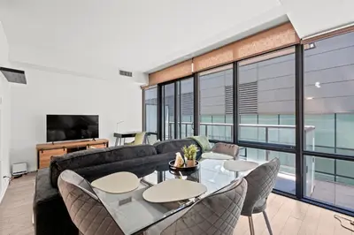 a living room with a couch and a table and chairs at Premium 1 Bedroom with City View in Toronto