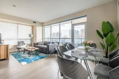a living room with a table and chairs at Stylish 2 BR & Den 2BA with Free Parking in Toronto
