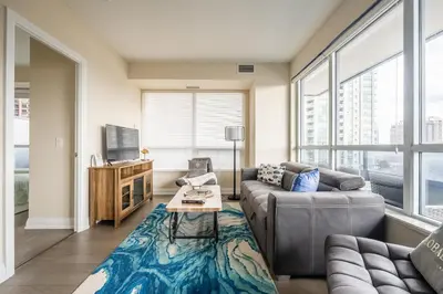 a living room with a couch and a table at Stylish 2 BR & Den 2BA with Free Parking in Toronto