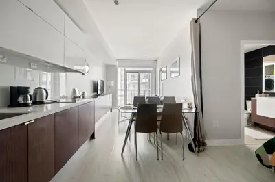 a kitchen and dining room with a table and chairs at High Floor 1 Bedroom plus Den Condo Iceboat Terrace Downtown Toronto in Toronto