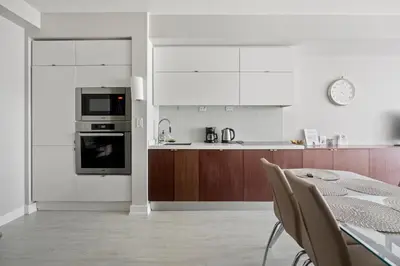 a white kitchen with a table and a stove top oven at High Floor 1 Bedroom plus Den Condo Iceboat Terrace Downtown Toronto in Toronto