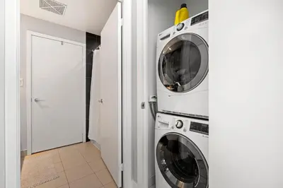 two washing machines in a white laundry room at High Floor 1 Bedroom plus Den Condo Iceboat Terrace Downtown Toronto in Toronto