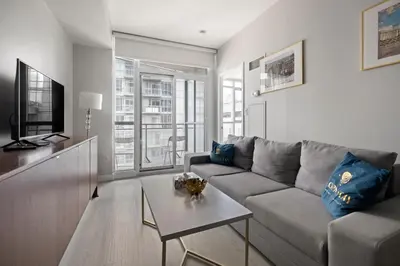a living room with a couch and a table at High Floor 1 Bedroom plus Den Condo Iceboat Terrace Downtown Toronto in Toronto