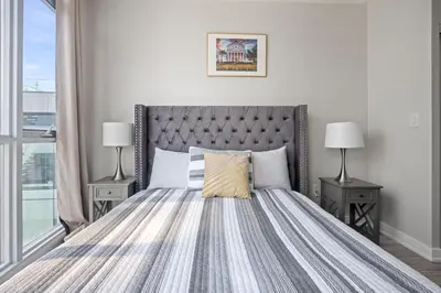 a bedroom with a bed with two night stands and two lamps at High Floor 1 Bedroom plus Den Condo Iceboat Terrace Downtown Toronto in Toronto