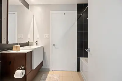a bathroom with a sink and a mirror and a shower at High Floor 1 Bedroom plus Den Condo Iceboat Terrace Downtown Toronto in Toronto