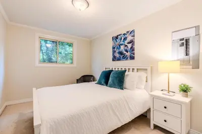 a bedroom with a white bed and a window at Family-Friendly 2BR - Sleeps 6 in Hamilton