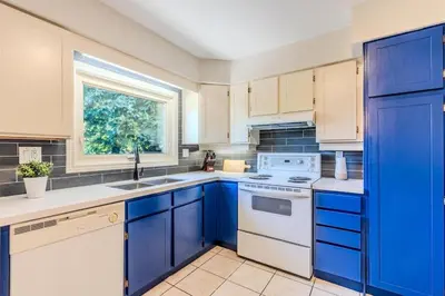 a blue kitchen with white appliances and a window at Family-Friendly 2BR - Sleeps 6 in Hamilton