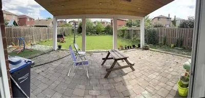 a patio with a picnic table and chairs in a backyard at Bright private single bedroom V02 on second floor in Mississauga