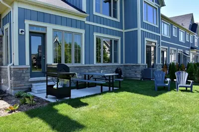 a blue house with a picnic table and chairs at Blue Mountain Village Townhome 4 Bedroom with Shuttle & Pool in Blue Mountains