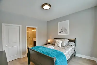 a bedroom with a bed with a blue blanket on it at Blue Mountain Village Townhome 4 Bedroom with Shuttle & Pool in Blue Mountains