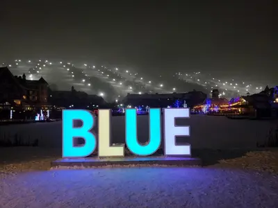 a blue sign that says blue at night at Blue Mountain Village Townhome 4 Bedroom with Shuttle & Pool in Blue Mountains