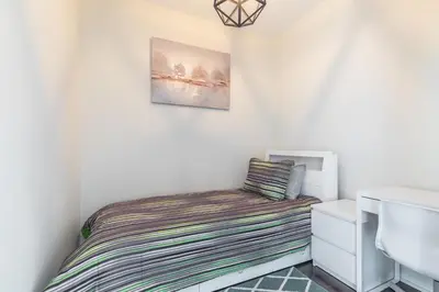 a small bedroom with a bed and a sink at Classic 1BR & Den Apartment in Downtown Gym Pool in Toronto