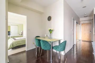 a dining room with a table and chairs and a bed at Classic 1BR & Den Apartment in Downtown Gym Pool in Toronto