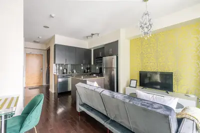 a living room with a couch and a tv at Classic 1BR & Den Apartment in Downtown Gym Pool in Toronto