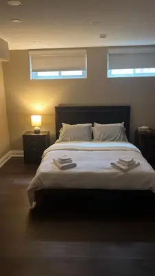 a bedroom with a large white bed with a window at Bright & Cozy Bankfield Stay in Toronto