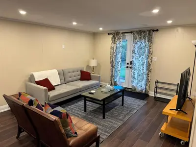 a living room with a couch and a table at Bright & Cozy Bankfield Stay in Toronto