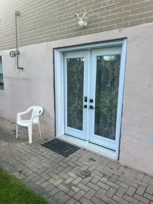 a white chair sitting in front of a door at Bright & Cozy Bankfield Stay in Toronto