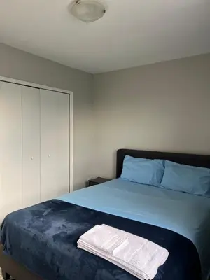 a bedroom with a bed with blue sheets and blue pillows at Modern Suite, 1 Guest Room in St. Catharines