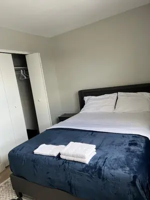 a bedroom with a bed with two towels on it at Modern Suite, 1 Guest Room in St. Catharines